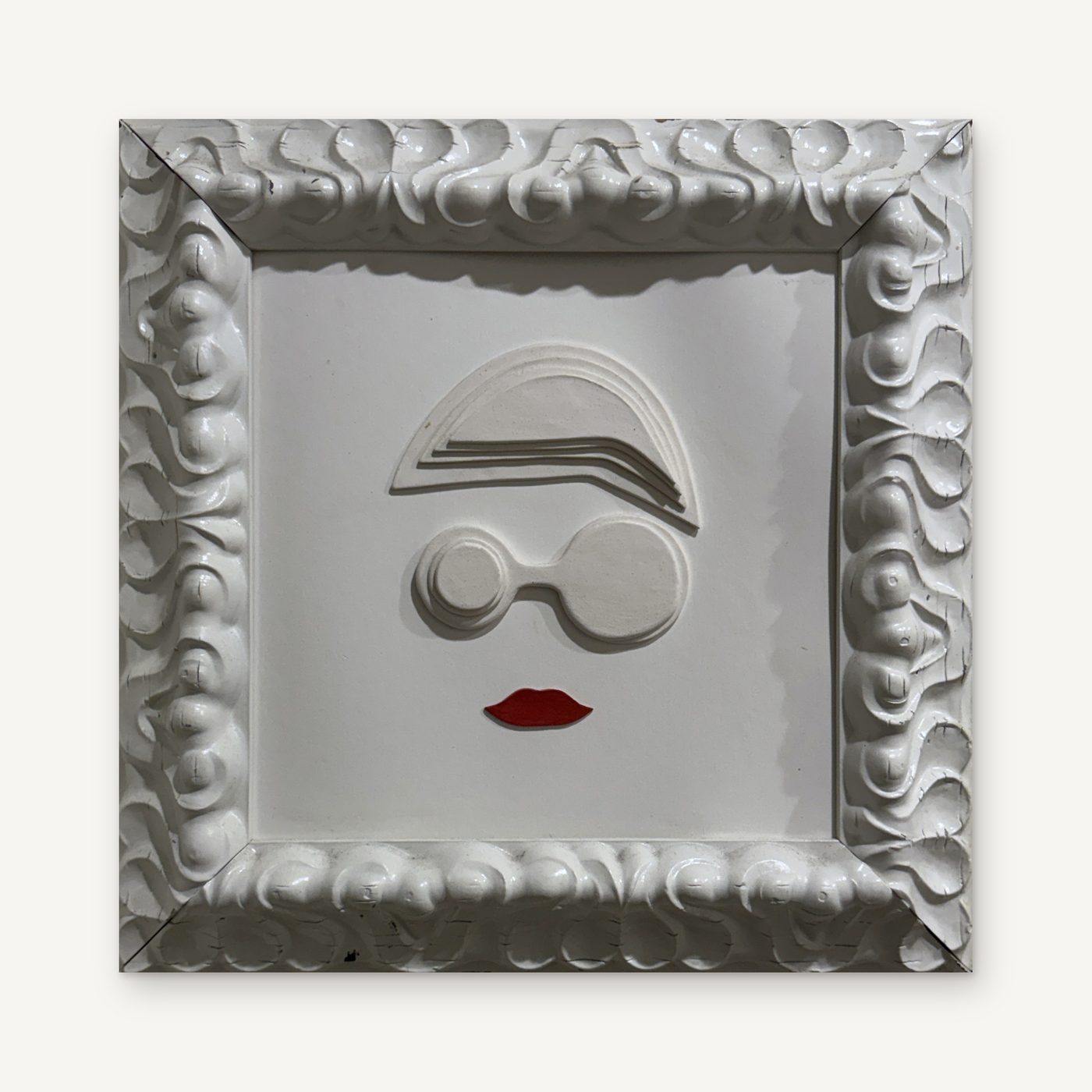 Manuel Pérez, Martica: a white porcelain face with round glasses and red lips in a sculpted white frame