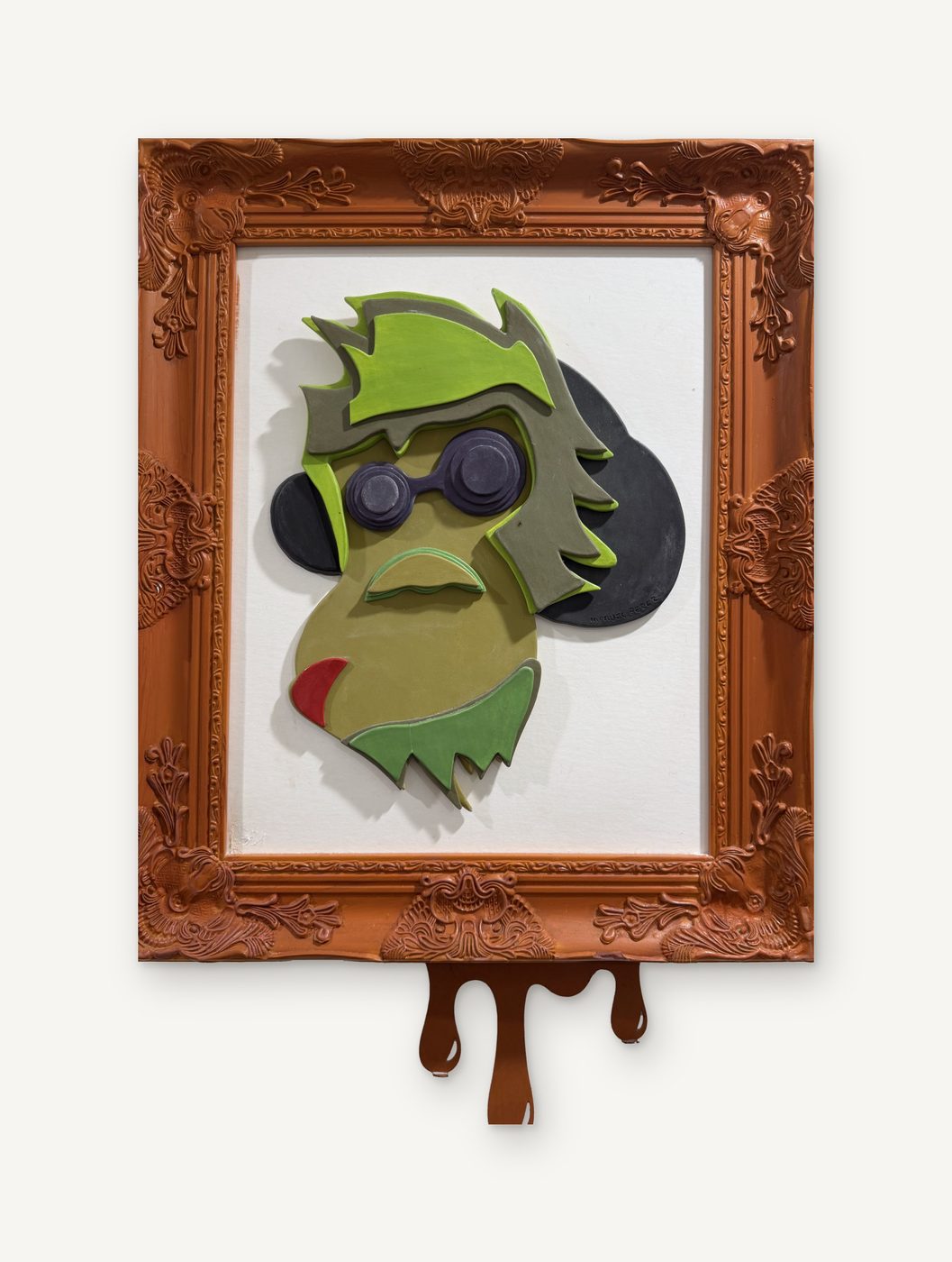 Manuel Pérez, Mono: a green porcelain monkey face with dark round glasses in an ornate copper frame with a brown drip below